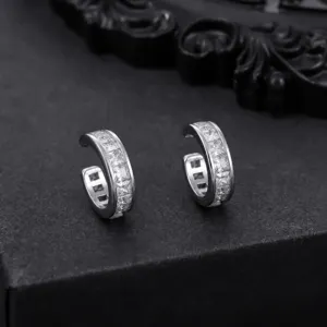 Primer plano detallado de pendientes de plata con piedras cuadradas y diseño elegante.