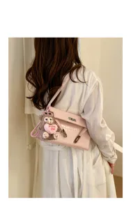 Pink embossed Kelly bag detail showing stylish shoulder strap and cute bear pendant design.