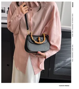 Vue détaillée du sac satchel rétro avec poignée en bambou, élégant sac bandoulière noir en cuir.