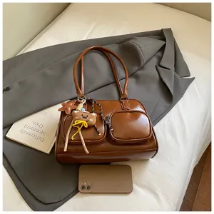 Borsa a tracolla bowling in pelle verniciata marrone con tasche anteriori e ciondolo orsetto.