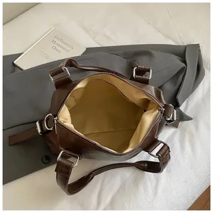 Detail interieur sac Boston marron montrant le compartiment spacieux et la doublure.