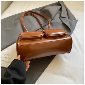 Borsa a spalla retrò in pelle verniciata marrone con due tasche frontali molto eleganti.