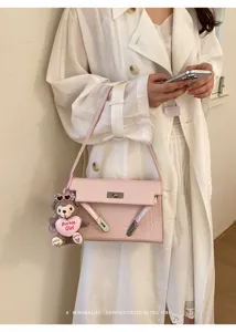 Retro pink croc embossed Kelly handbag detail with cute Barbie plush bear keychain accessory.