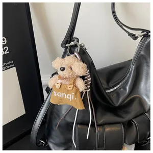 Detailed view of retro textured large capacity women shoulder bag with cute fluffy bear pendant.