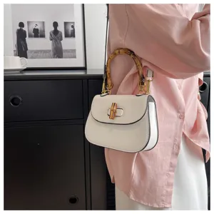 Gros plan détaillé du sac de selle vintage élégant doté d'une poignée en bambou et d'un fermoir.