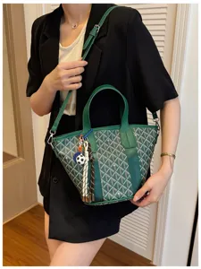 Detailed view of the green chevron pattern bucket bag with stylish charms and leather strap.