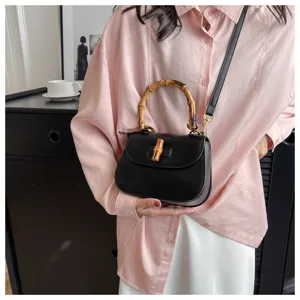 Sac à main noir en cuir avec poignée en bambou et fermoir élégant pour femme chic.
