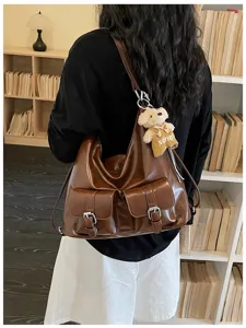 Detail shot of retro brown leather convertible backpack and shoulder bag with multiple pockets.