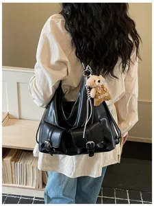 Retro black large shoulder bag detail showing double front pockets and cute bear pendant.