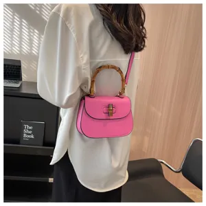 Vue détaillée du sac de selle rose avec poignée en bambou unique et verrou chic, design élégant.