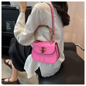 Vue détaillée du sac cartable rose vintage à poignée en bambou, élégant sac bandoulière.