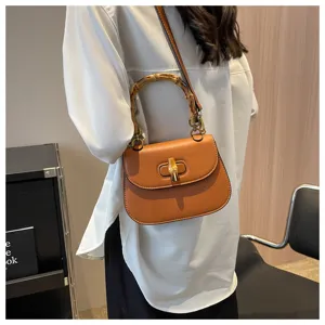 Sac de selle marron rétro avec poignée élégante en bambou et fermeture sécurisée.