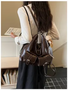 Detail view of retro dark brown leather convertible backpack and shoulder bag with multi pockets.