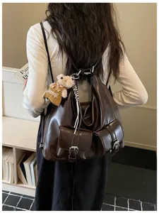 Detailed view of vintage dark brown PU leather multi-purpose backpack with front pockets.
