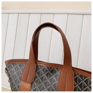Detail view of stylish women geometric pattern tote bag with brown leather handles and trim.