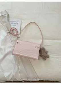 Pink crocodile pattern leather shoulder bag with chic metal lock closure and cute bear pendant.