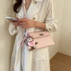 Retro women's Kelly shoulder bag, chic luxury PU leather handbag with cute bear plush pendant.