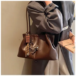 Stylish brown leather tote bag with cute charms, large capacity commuter shoulder bag.