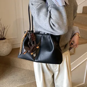 Stylish black faux leather shoulder tote bag for women, featuring casual design and charms.