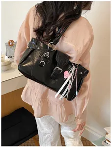 Fashion retro black shoulder bag detail view showcasing leather and cute ribbon charm.