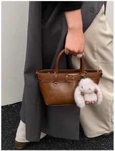 Borsa a secchiello retro in pelle marrone con ciondolo peluche per donne eleganti.