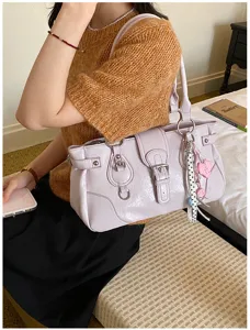 Stylish retro lavender shoulder bag detail showing delicate buckles, chains, and textured leather.