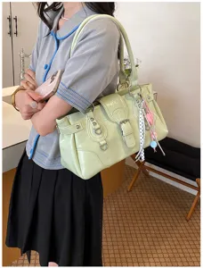Stylish vintage retro underarm shoulder bag with metal rings and chic ribbon charm detail.