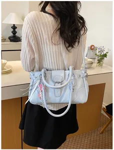 Detailed view of the stylish light blue retro shoulder bag with metallic buckle accent.