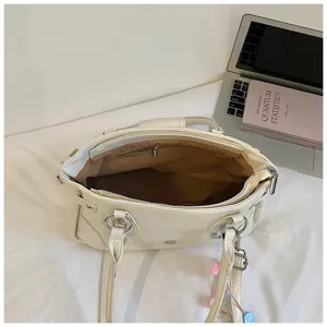 Close-up interior detail of off-white retro underarm tote shoulder bag with spacious lining.