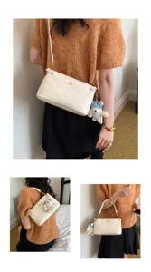 White quilted underarm shoulder bag for women, chic commuting crossbody bag with cute charm.
