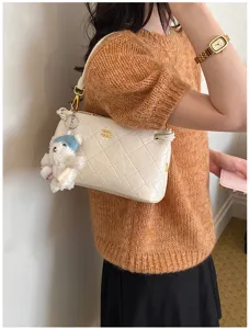 Chic quilted underarm bag detail shot, beige design with cute bear charm and gold hardware.