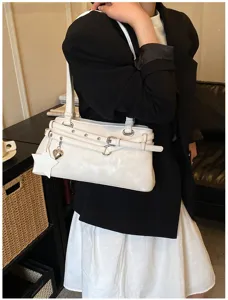 Chic white leather shoulder bag for women, featuring stylish buckle strap and cute charms.