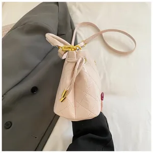 Pink quilted bucket shoulder bag detail showcasing diamond pattern and gold hardware.
