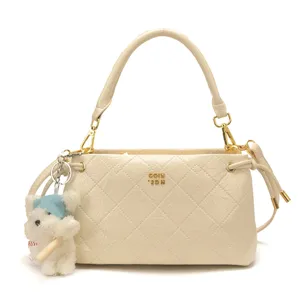 Chic off-white quilted shoulder bag for women, trendy underarm handbag with cute bear charm.