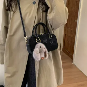 Chic black bowling shoulder bag with cute fluffy bunny pendant, stylish casual daily crossbody.
