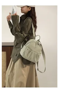 Detail view of casual nylon backpack in sage green with adjustable straps for daily use.