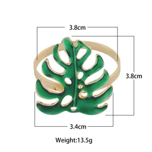 Metal tropical leaf napkin ring with gold trim and size specifications for table decor.
