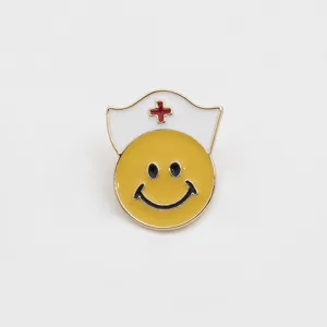 Metal nurse smiley face enamel pin, cute medical theme backpack jacket badge detail shot.