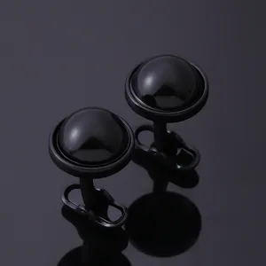 Gemelos redondos negros minimalistas para hombre con un elegante diseño de cúpula pulida.