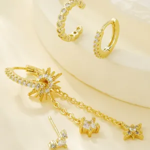 Vue détail boucles d'oreilles pampilles étoile dorées, ensemble bijoux zircon céleste près.