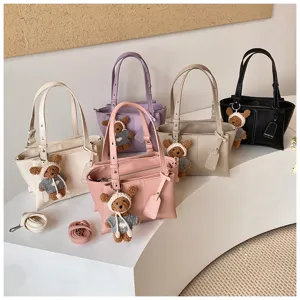 Detailed view of women fashion PU leather tote shoulder bag with cute bear charm and straps.