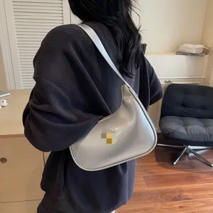 Silver glossy crescent shoulder bag for women, stylish underarm hobo bag with sleek design.