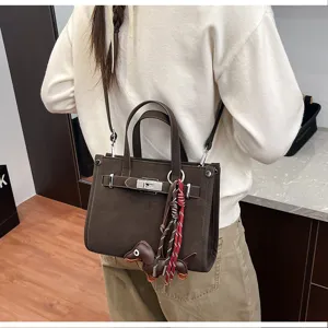 Stylish brown shoulder bag for women with chic lock hardware and cute dog charm detail.