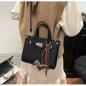 Stylish black PU leather shoulder bag for women, trendy crossbody bag with chic lock and charm.