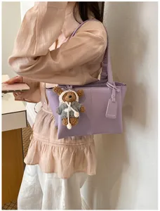 Elegant purple shoulder tote bag for women, stylish commuting handbag with cute bear charm.