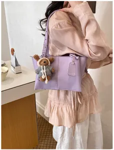 Detailed view of women's trendy purple tote bag with cute bear pendant for daily commute.