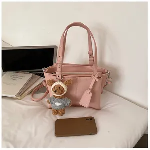 Pink tote handbag for women with cute crochet bear pendant, stylish PU leather shoulder bag.