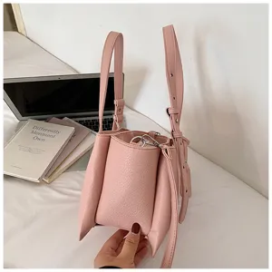 Pink leather handbag detail showing unique pleated texture, dual handles and metal hardware.