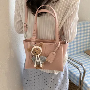 Stylish pink leather tote bag for women, large capacity shoulder underarm handbag with cute bear pendant.