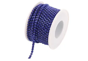 Dark blue rhinestone cup chain trim on white spool for DIY phone cases and crafts.